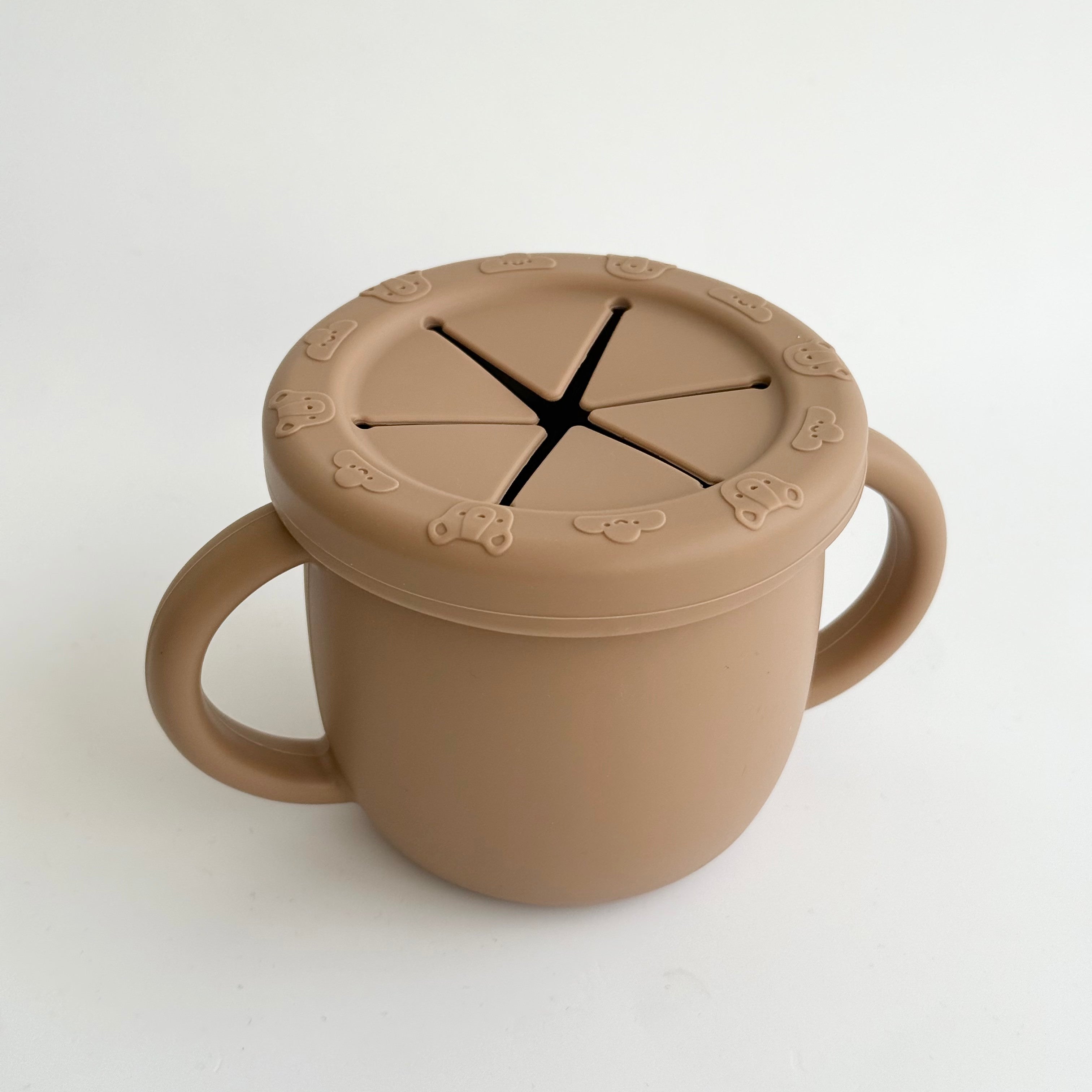 Brown silicone snack cup with soft spill-proof lid and handles for baby and toddler self-feeding