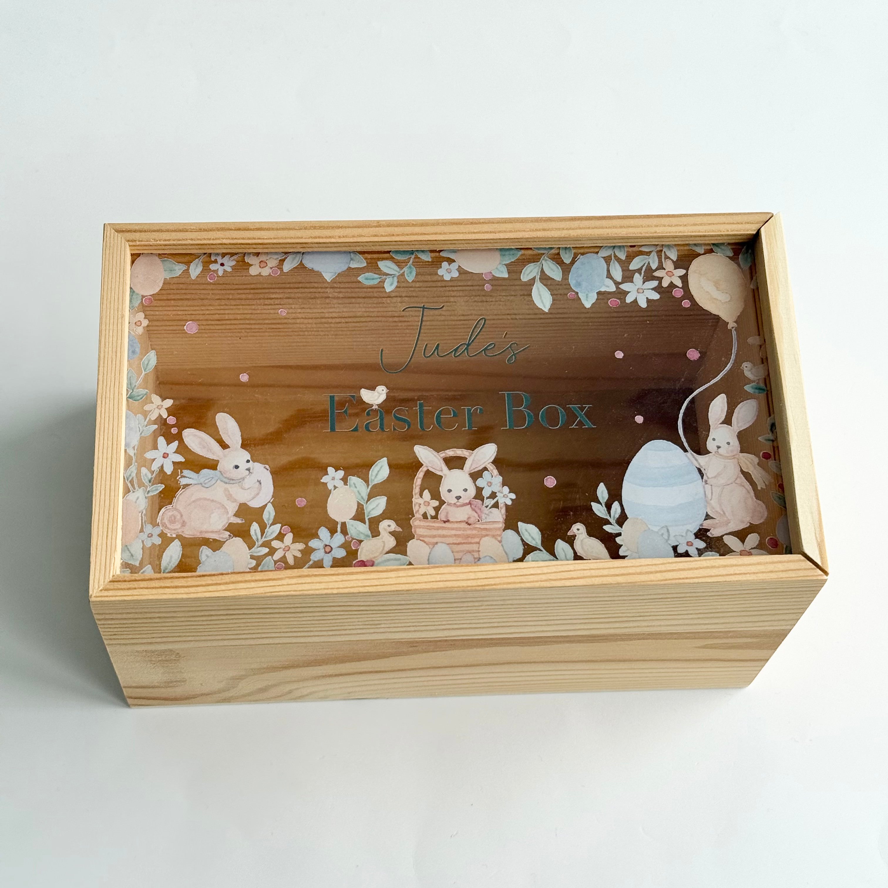 Personalised wooden Easter keepsake box with bunny illustrations and the name Jude engraved on the lid, designed for storing Easter gifts and memories