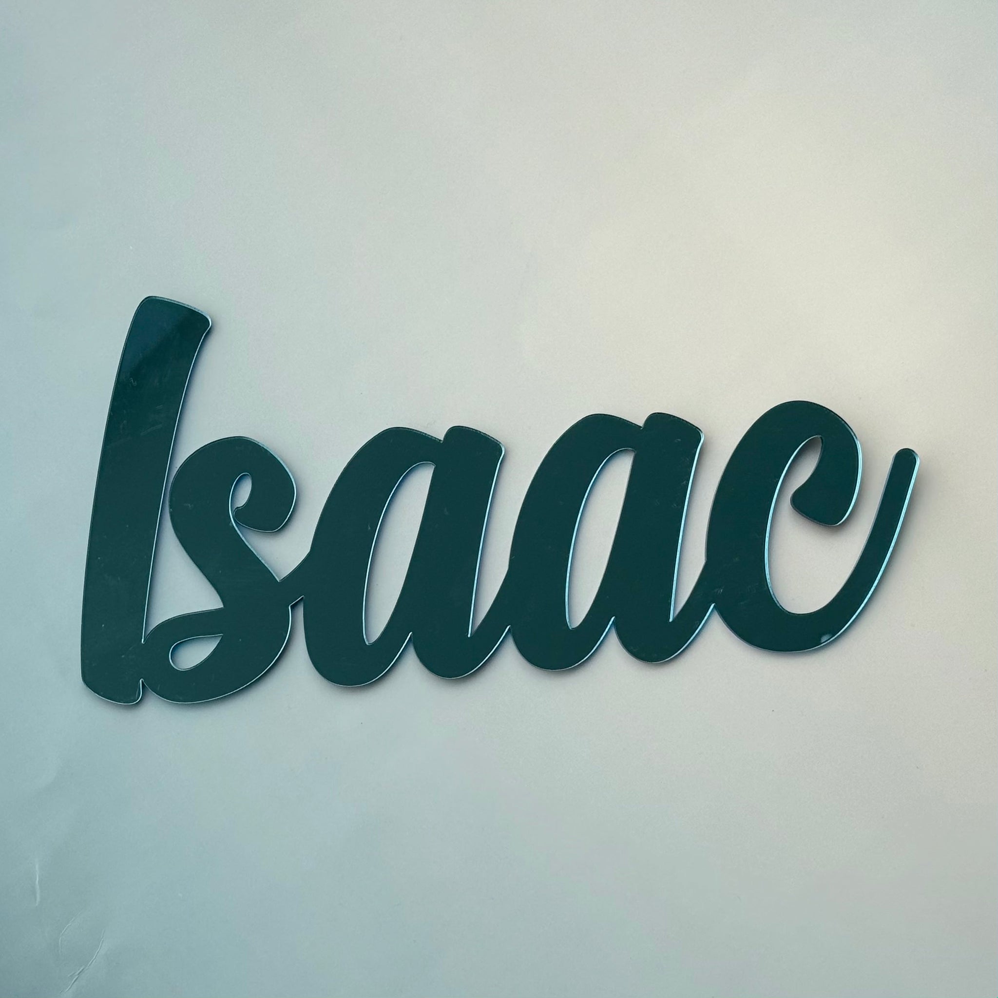 Personalised acrylic name sign reading Isaac in a modern script style, designed as wall decor for a nursery or kids bedroom