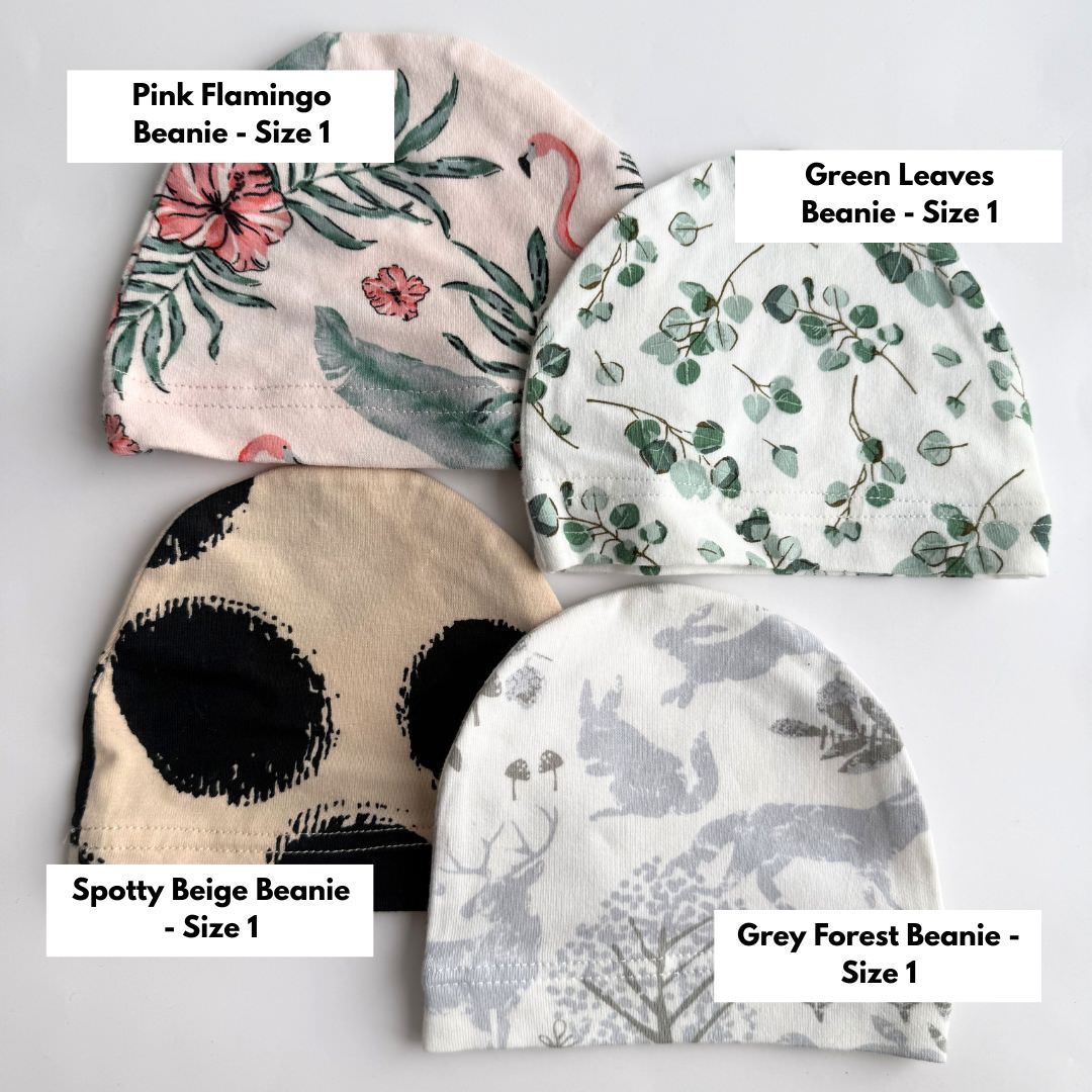 Clearance size 1 baby beanies including pink flamingo, green leaves, spotty beige and grey forest prints.