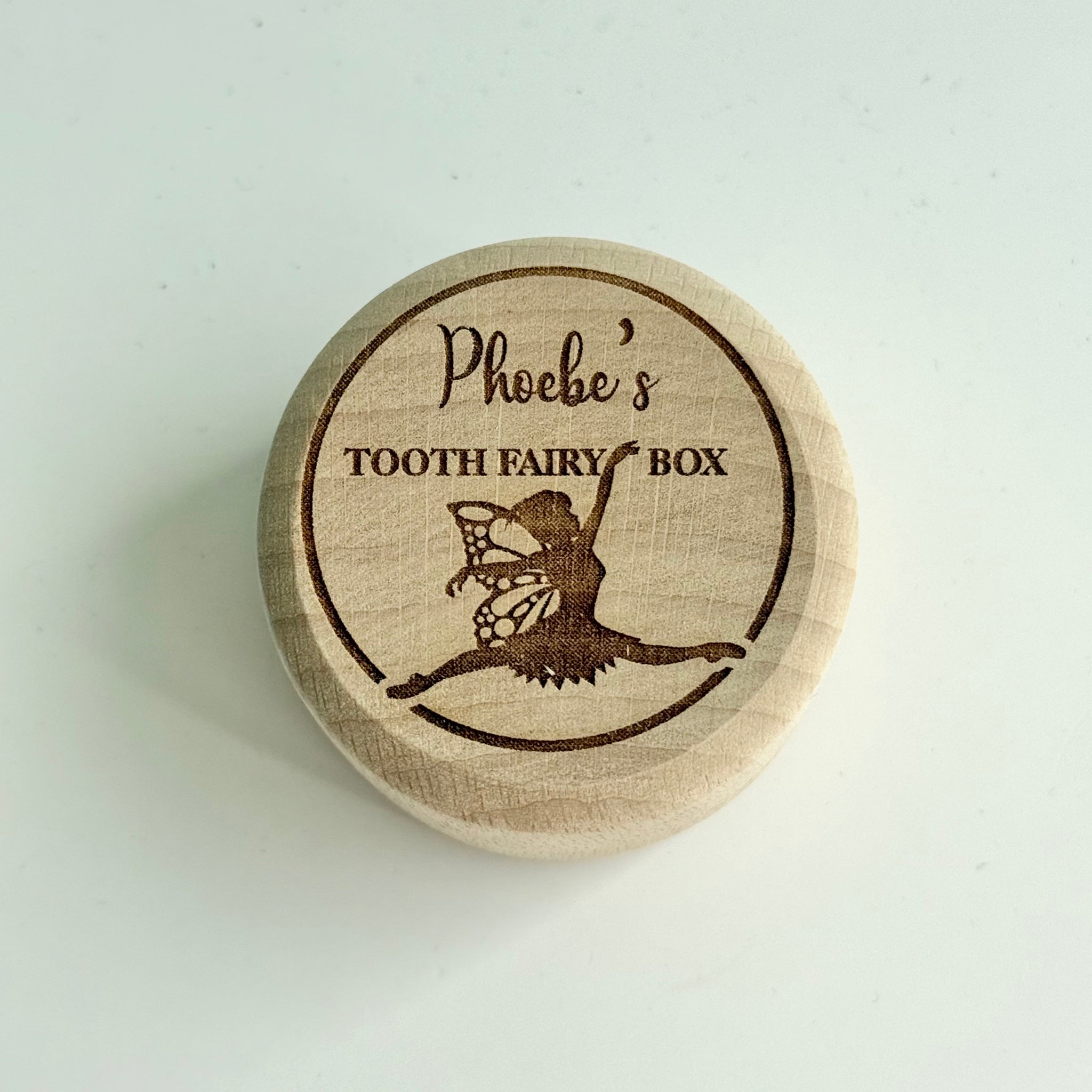 Personalised round wooden tooth fairy box engraved with fairy illustration and child’s name on lid