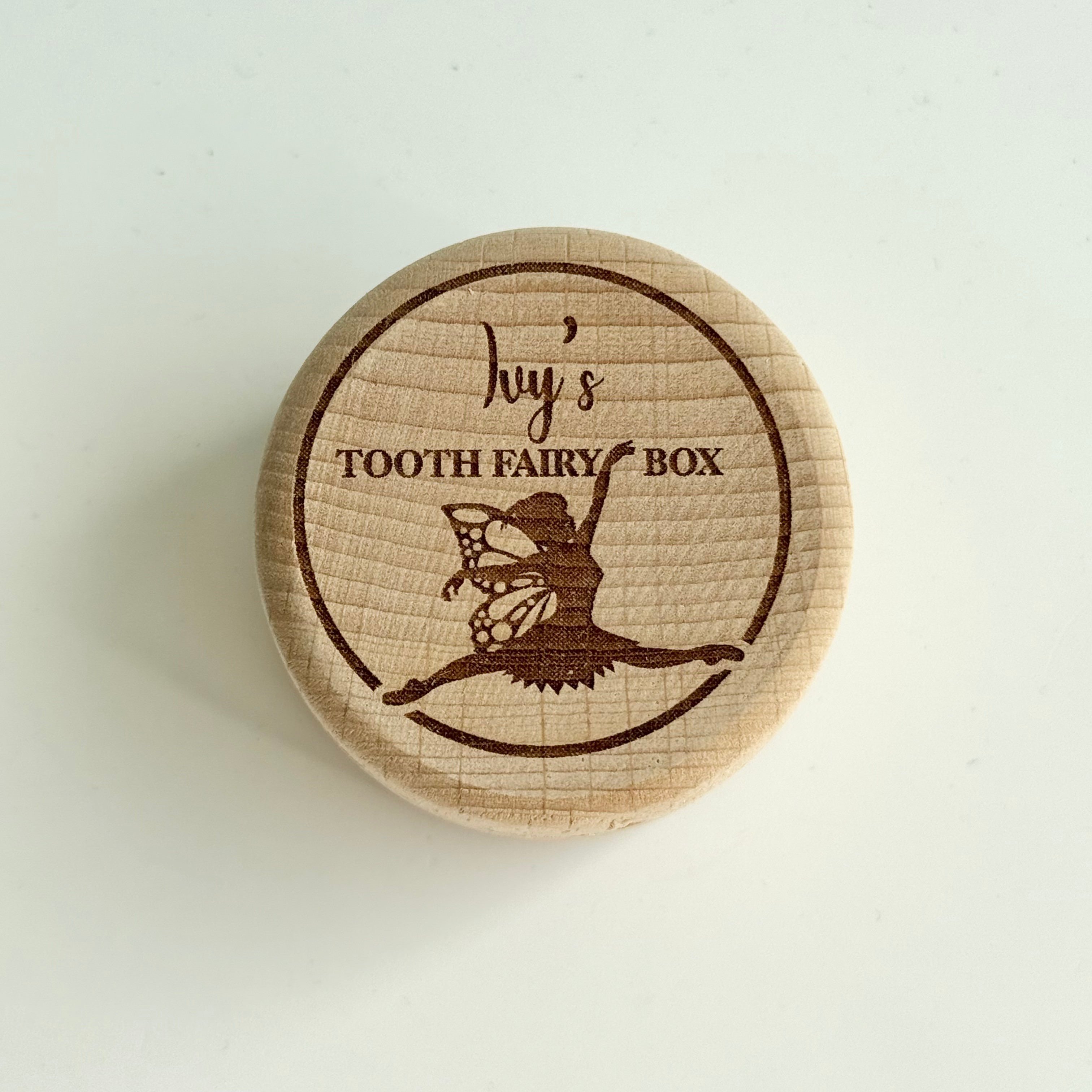 round wooden personalised tooth fairy box engraved with fairy illustration and child’s name on lid