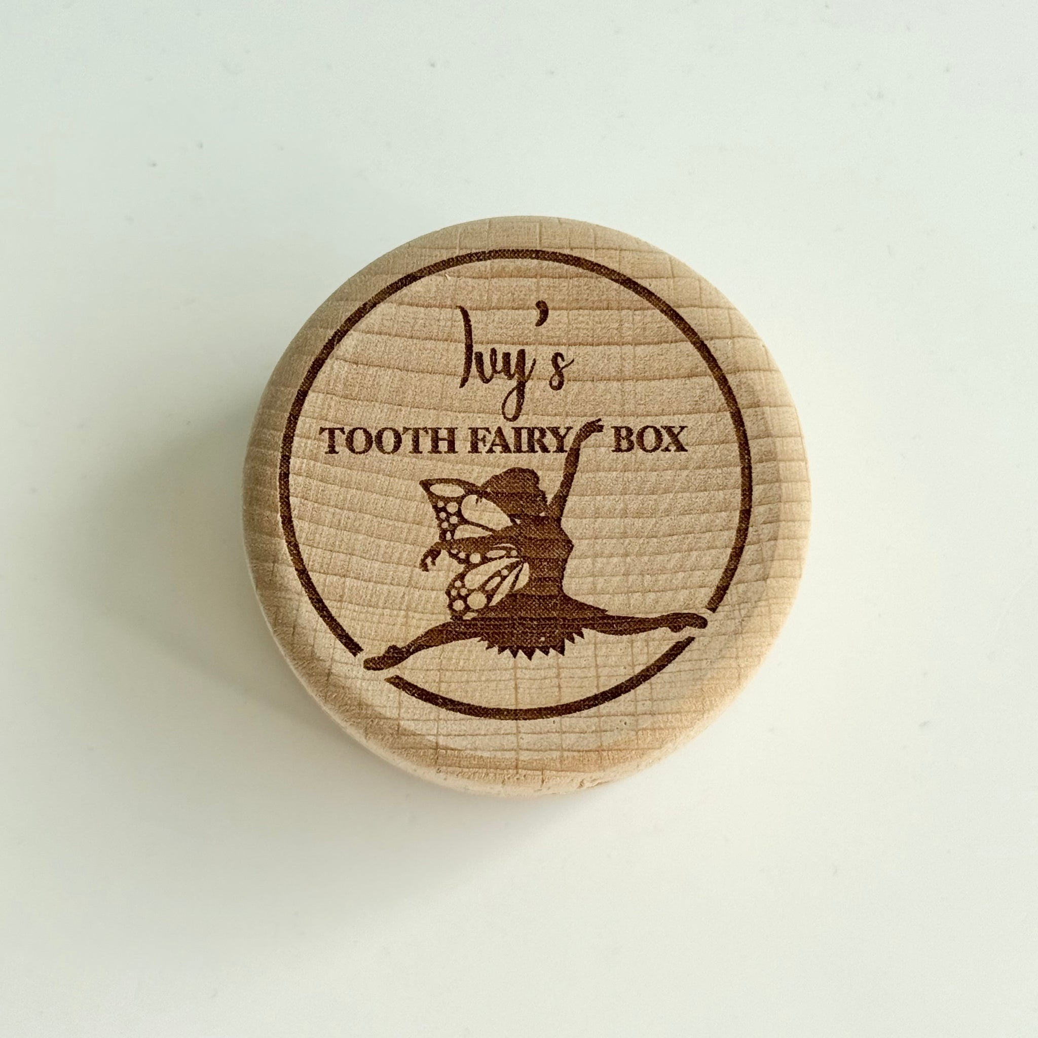 round wooden personalised tooth fairy box engraved with fairy illustration and child’s name on lid