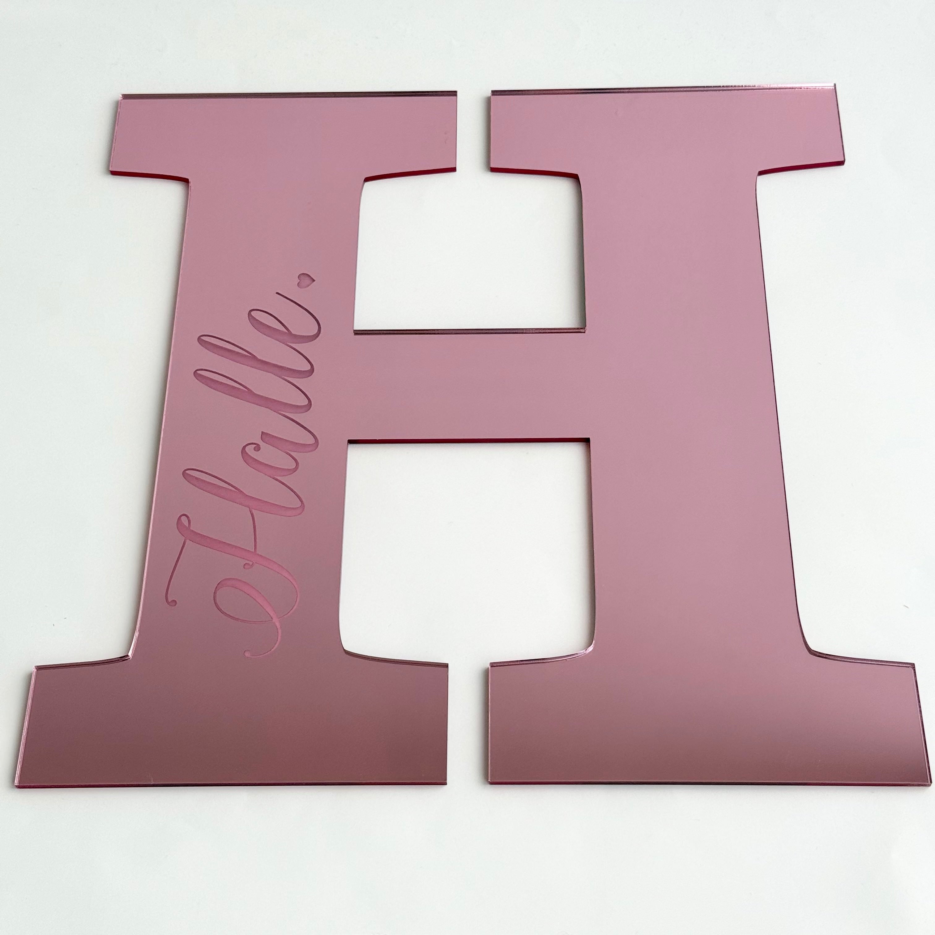 Personalised acrylic letter H plaque in pink with the name Hallie engraved, designed for nursery or kids room decor