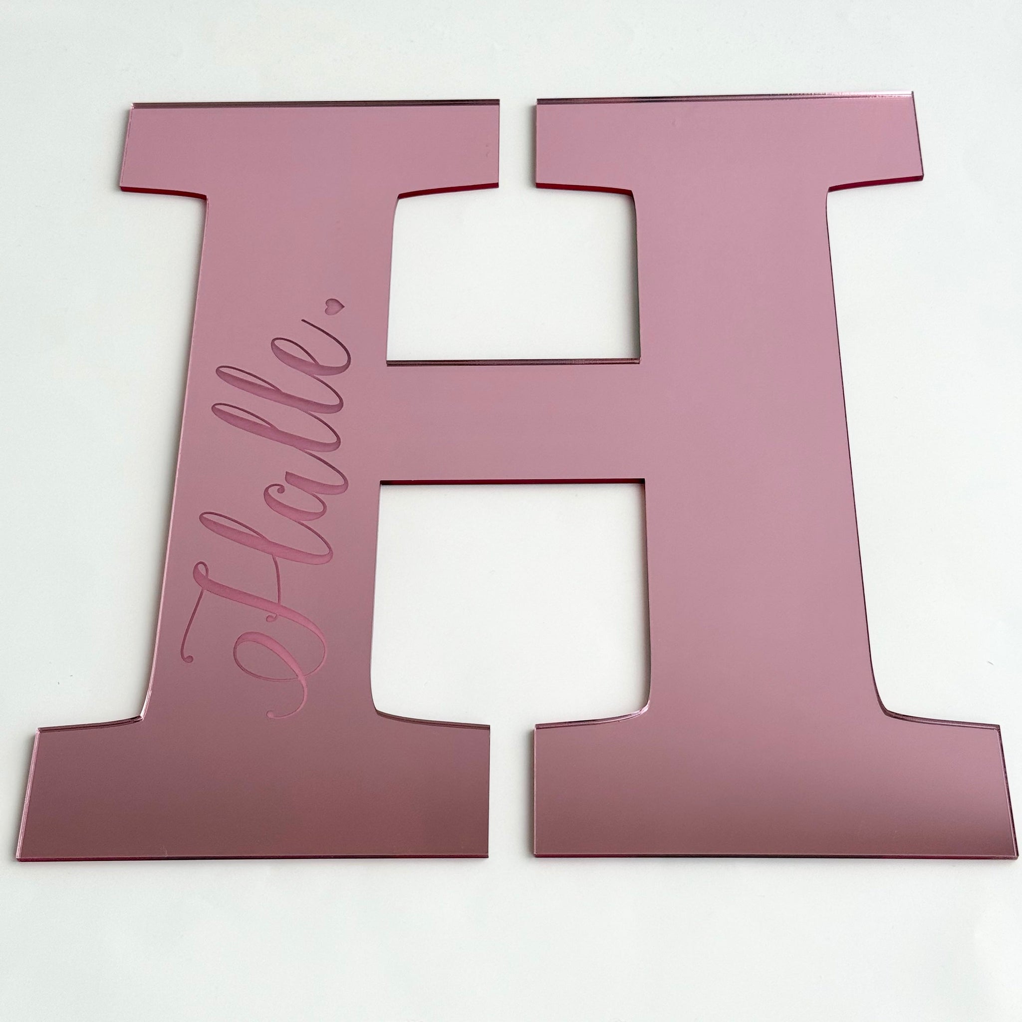 Personalised acrylic letter H plaque in pink with the name Hallie engraved, designed for nursery or kids room decor