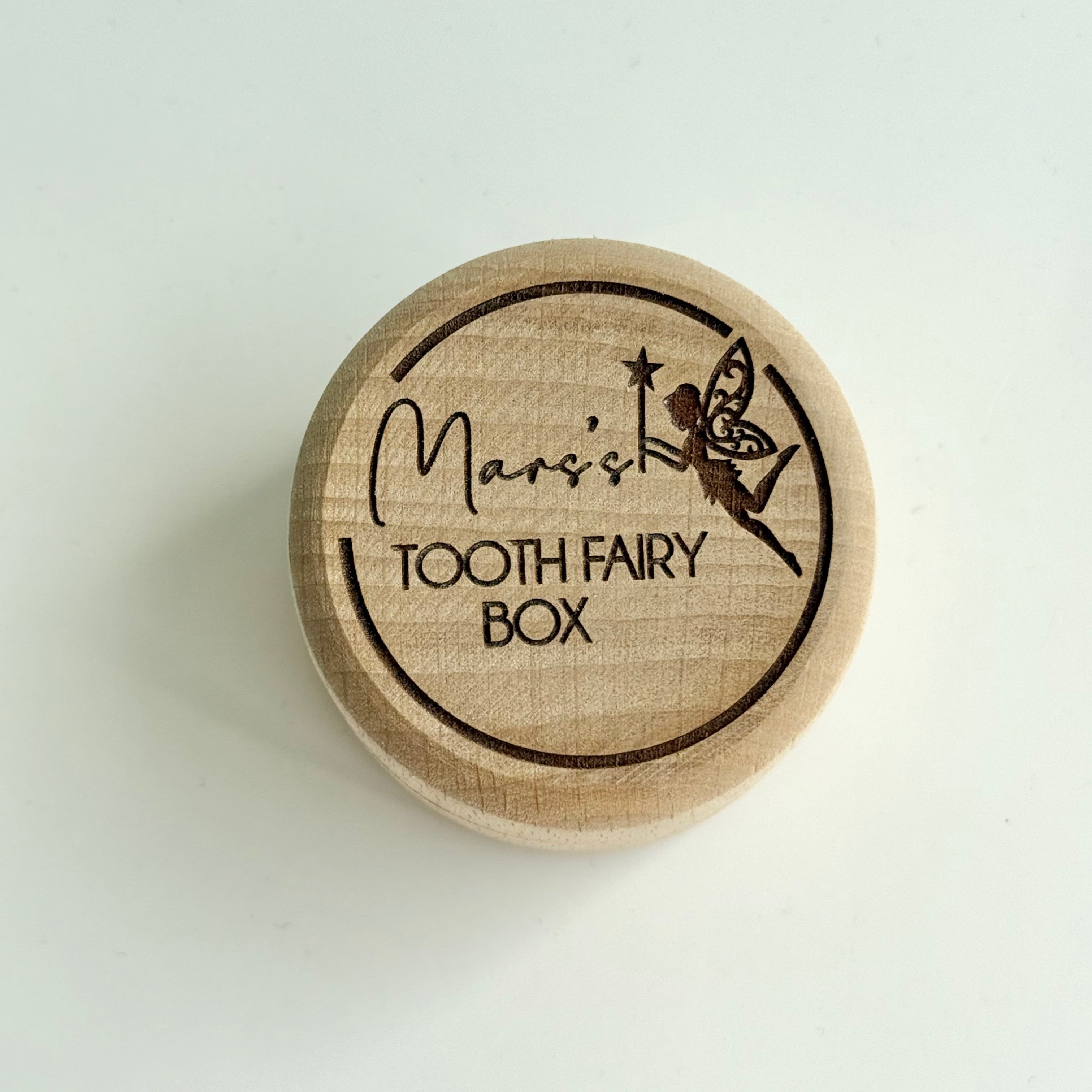 Personalised round wooden tooth fairy box engraved with fairy illustration and child’s name on lid