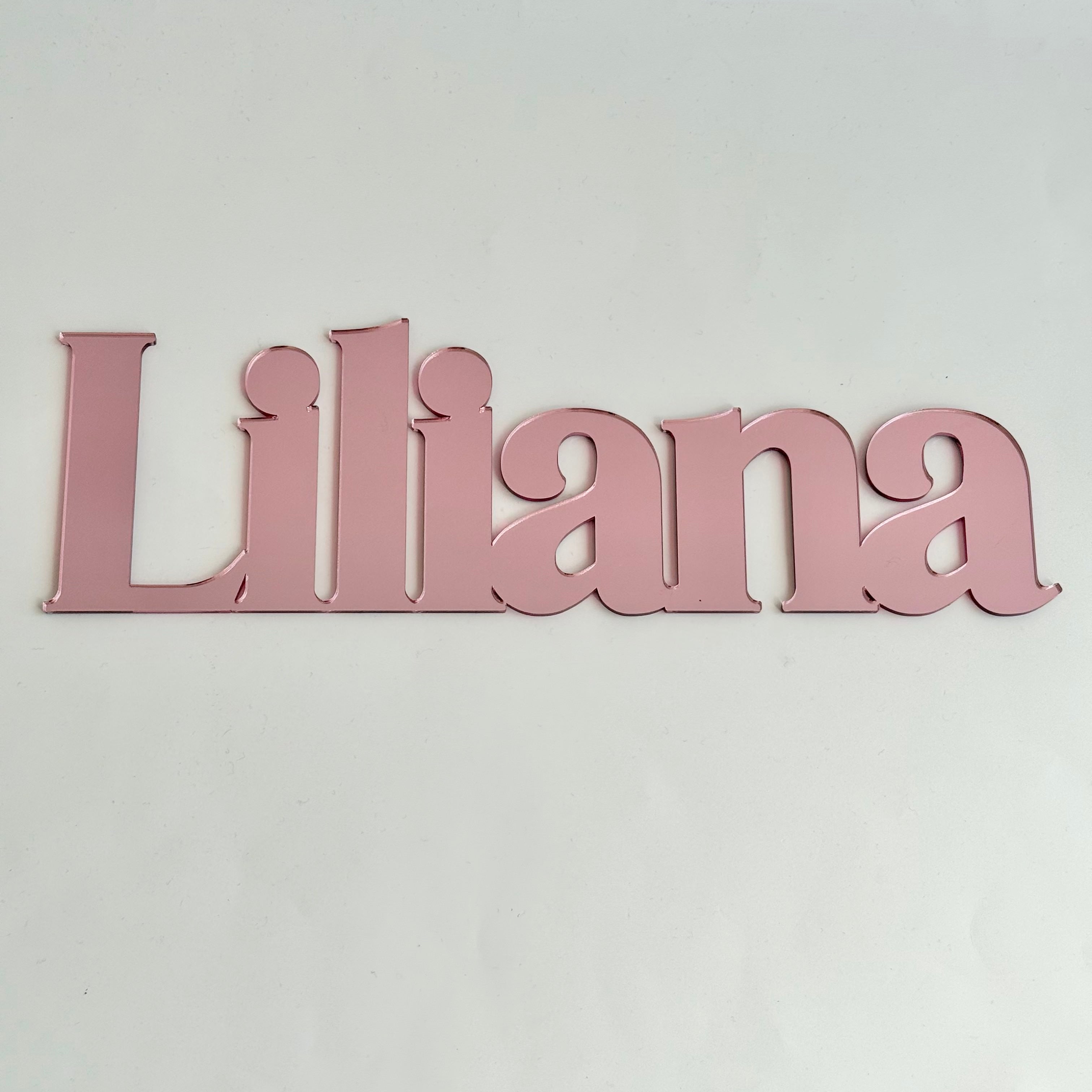 Personalised pink acrylic name sign reading Liliana, designed as stylish wall decor for a child’s bedroom or nursery