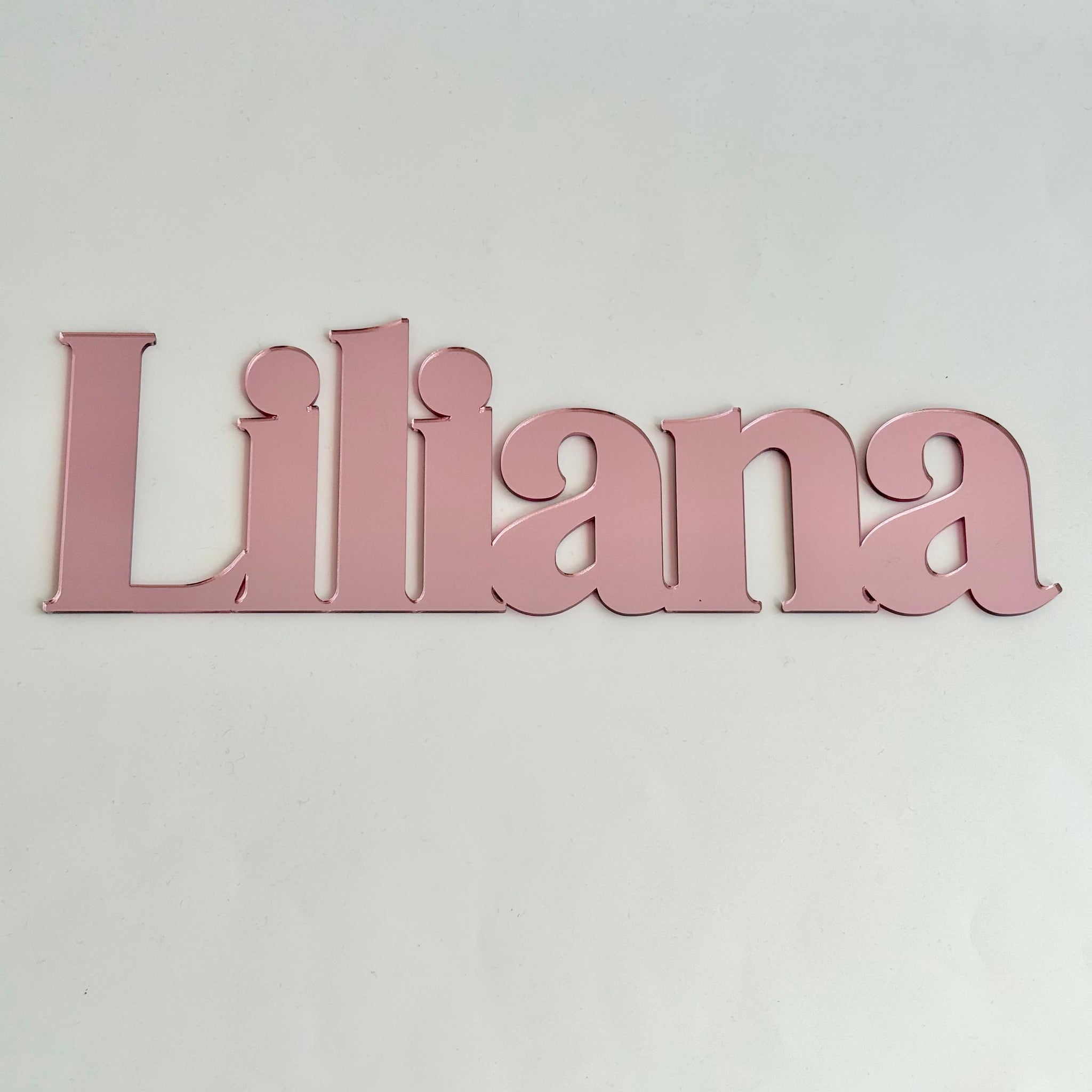Personalised pink acrylic name sign reading Liliana, designed as stylish wall decor for a child’s bedroom or nursery
