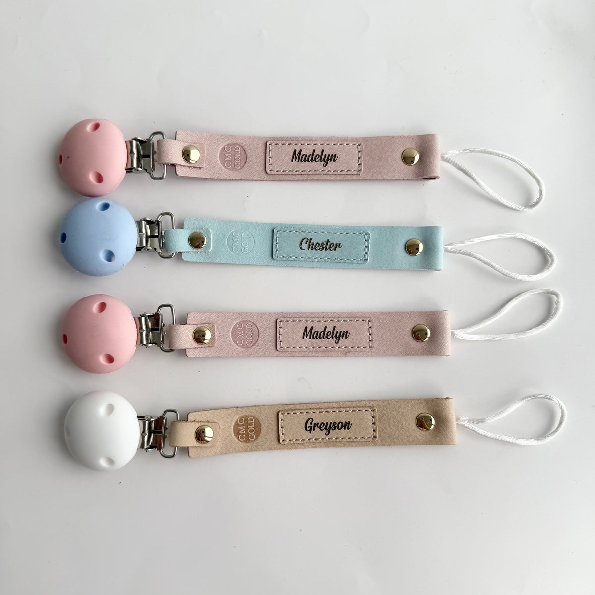 Personalised dummy clips with engraved names , silicone clip and loop attachment in baby blue, baby pink and oatmeal.