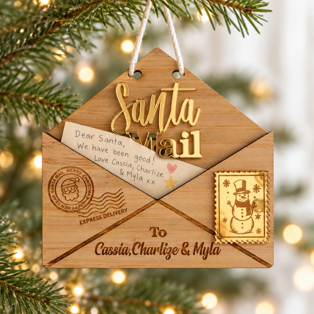Personalised Santa Mail Christmas ornament with timber envelope, gold acrylic lettering and children's names hanging on a Christmas tree