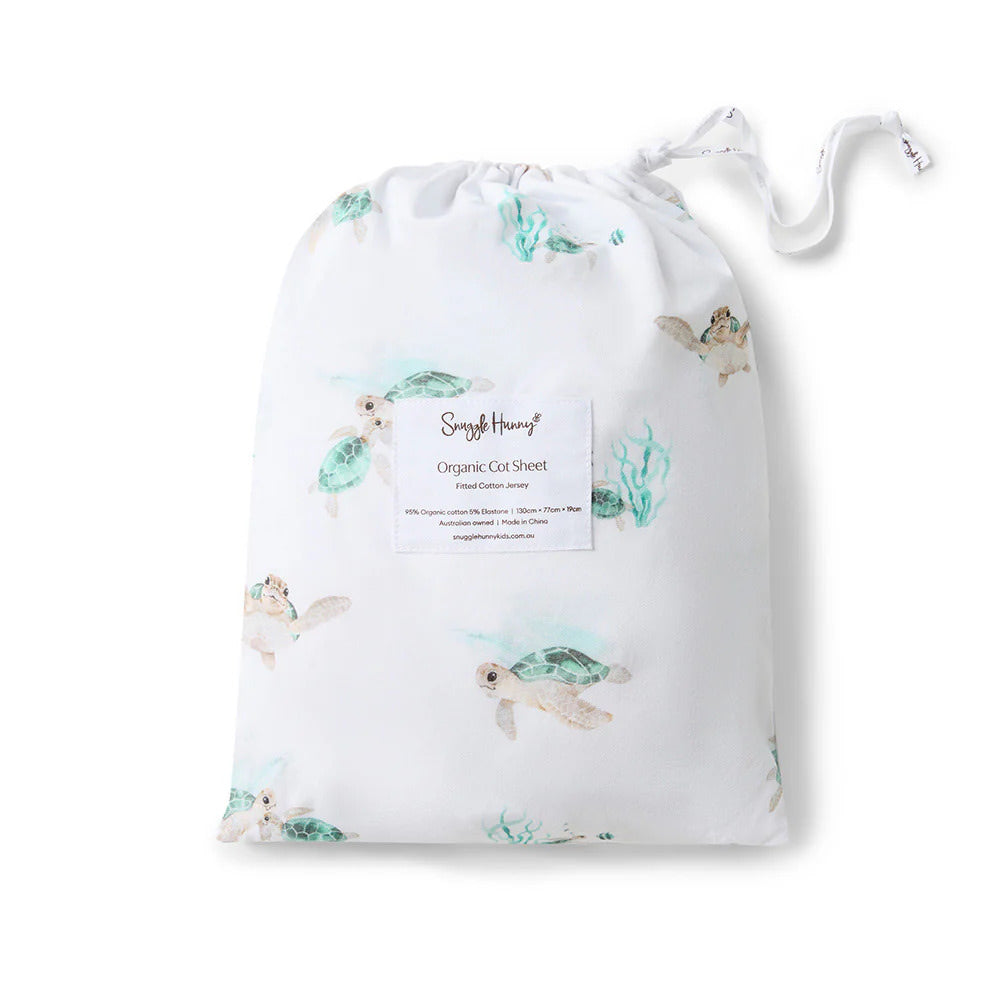 Turtle print baby cot sheet packaged in matching drawstring storage bag with sea turtle pattern