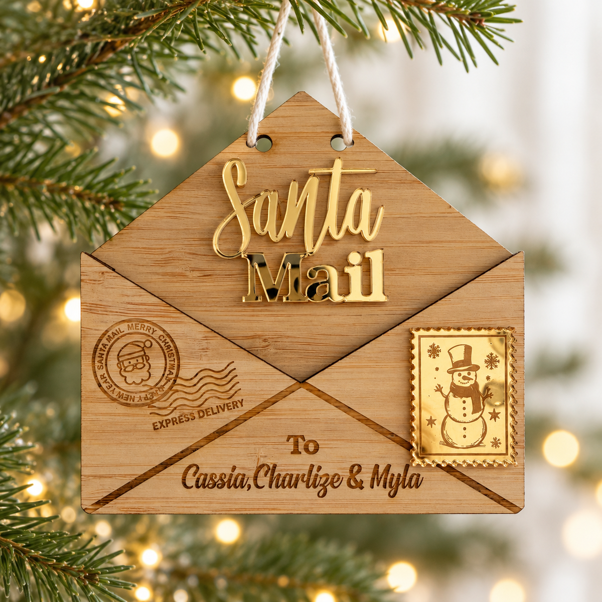 Personalised Santa Mail Christmas ornament with timber envelope, gold acrylic lettering and children's names hanging on a Christmas tree