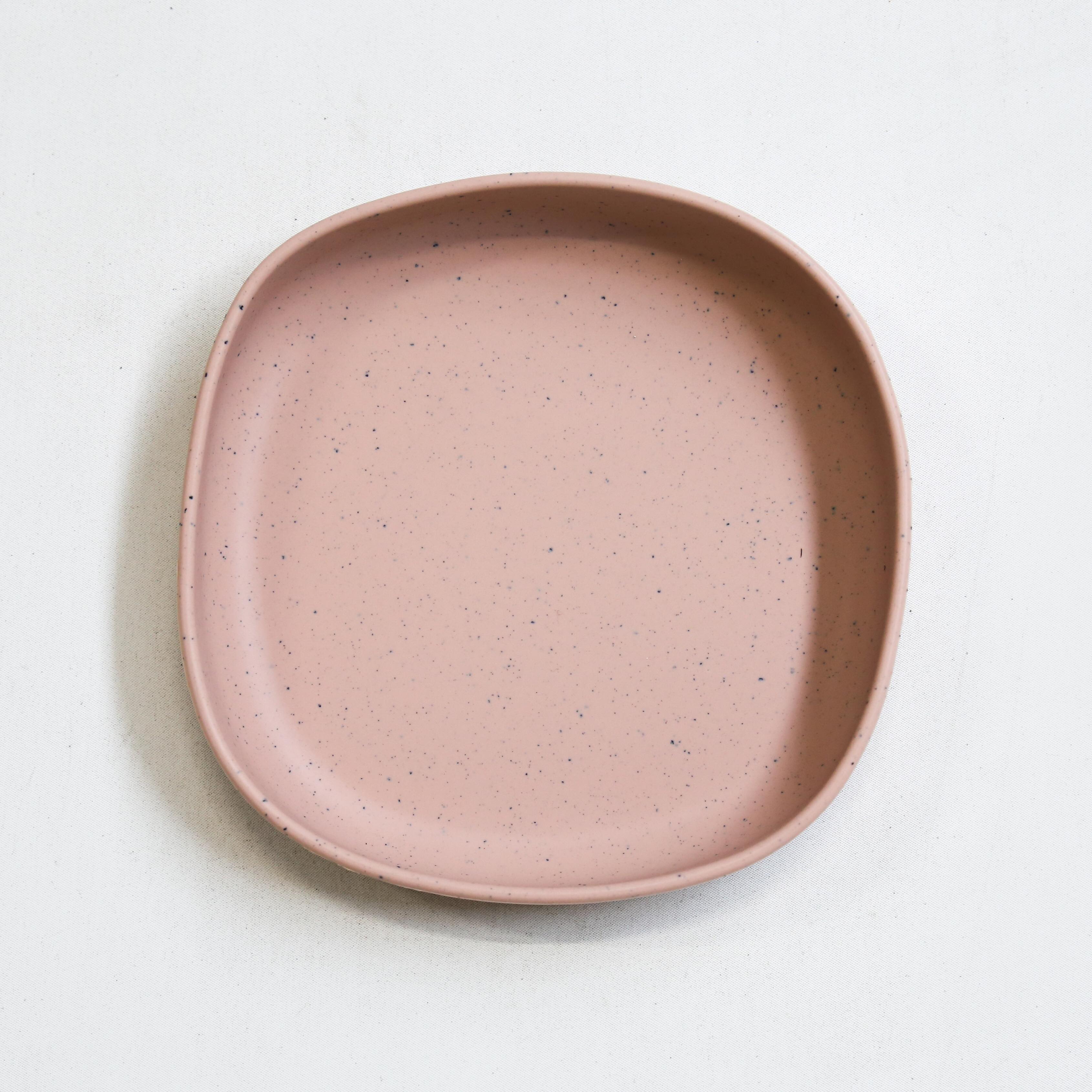 Blush silicone kids plate with speckled finish, non suction design, shown on a neutral background.